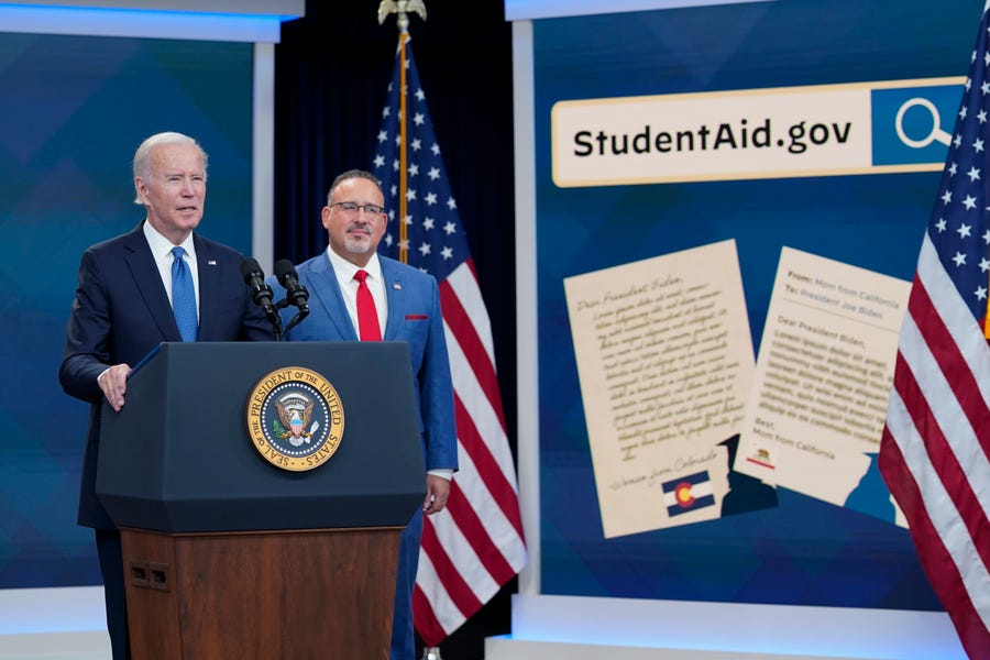 President Joe Biden speaks about the student debt relief portal beta test as Education Secretary Miguel Cardona listens in the South Court Auditorium on the White House complex in Washington, Monday, Oct. 17, 2022.