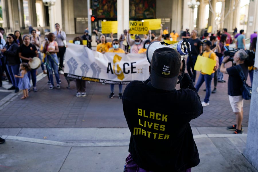 Protesters chant a slogan outside the Los Angeles City Hall in Los Angeles, Tuesday, Oct. 18, 2022. The demonstrators demanded the city council stop its virtual meeting Tuesday until two of its members resign over racist remarks.