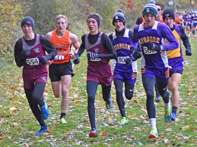 Battling the cold and rainy conditions on their way to the finish at Tuesday's Big 8 Jamboree were, from left, Union City's Jason Shoop, Quincy's Jacob Reif, Union City's Ben Gautsche, Bronson's Ashton Wells, and Bronson's Aden Hathaway.