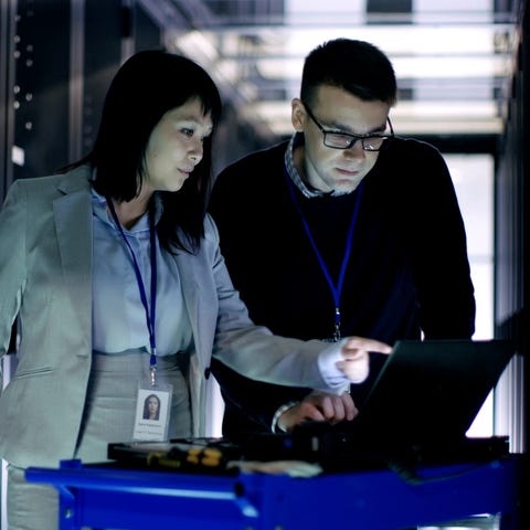 A man and woman look at a computer