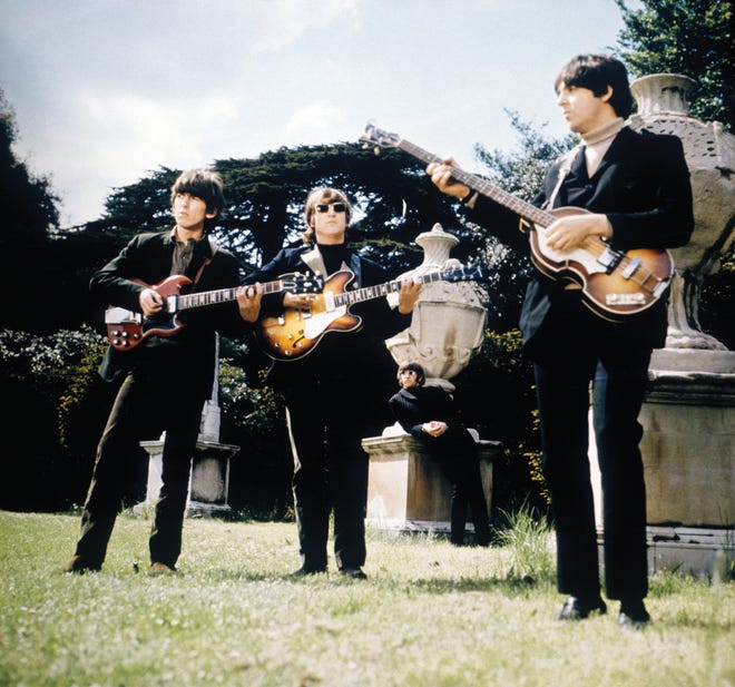 The Beatles (left to right, George Harrison, John Lennon and Paul McCartney, with Ringo Starr in the background) in the gardens of Chiswick House, a villa in London, to film music videos for "Paperback writer" and "Rain" May 20, 1966.