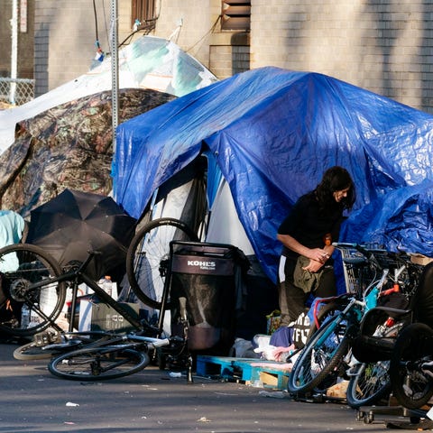 Tents of a homeless camp line the sidewalk in 2021
