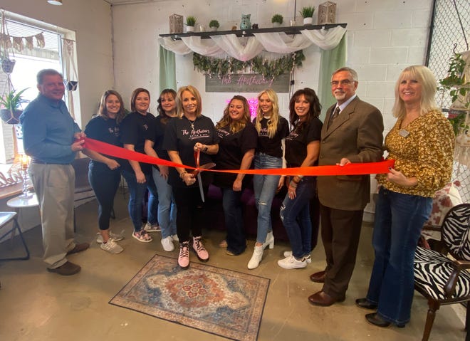 Rhonda Tinsley gets ready to cut the ribbon on the Apothecary Salon and Spa along with staff, Martinsville Mayor Kenny Costin and representatives from the Martinsville Chamber of Commerce.