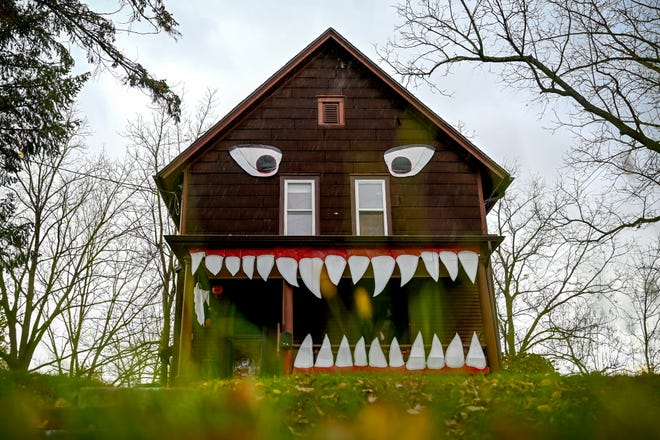 The front of a home on High Street near Lake Lansing Road is transformed into a monster with eyes above large teeth fixed to the front porch on Monday, Oct. 17, 2022, in Lansing.