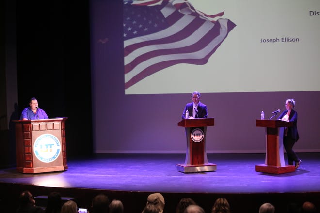 As moderator Chris Reed looks on, candidates Joseph Elison and Ila Fica, who are competing for a seat in the Utah House of Representatives, speak during a debate hosted by the Washington County Debate Coalition at Utah Tech University.