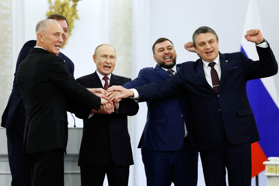 In this file photo taken on September 30, 2022 (L-R) The Moscow-appointed heads of Kherson region Vladimir Saldo and Zaporizhzhia region Yevgeny Balitsky, Russian President Vladimir Putin, Donetsk separatist leader Denis Pushilin and Lugansk separatist leader Leonid Pasechnik join hands after signing treaties formally annexing four regions of Ukraine Russian troops occupy, at the Kremlin in Moscow. Russian President Vladimir Putin on October 19, 2022 introduced martial law in Ukraine's Donetsk, Lugansk,   Kherson and Zaporizhzhia regions that Moscow claims to have annexed.