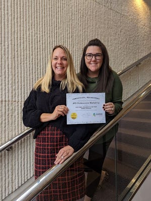 Paig Lamp (left), co-founder and managing partner of JPB, and Bailey DeWitt, director of operations, proudly display the nomination certificate for Small Business of the Year.