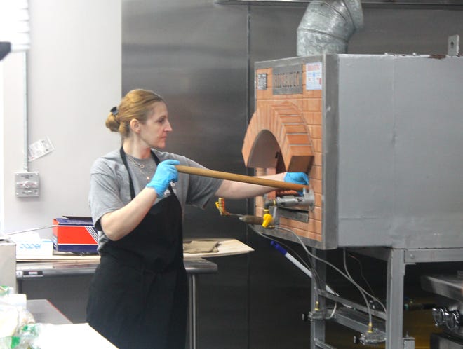 Hanadi Fregat puts pita in the oven at her restaurant on Seven Mile west of Farmington Road in Livonia.