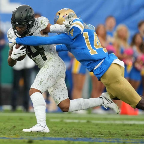 UCLA defensive back DJ Warnell (right) forces a fu