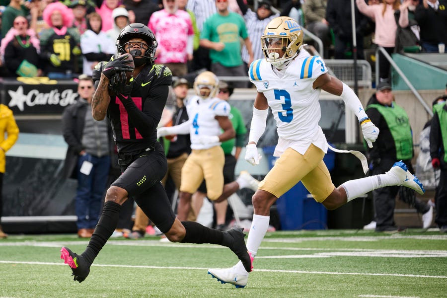 Oregon Ducks WR Troy Franklin (11) catches a touchdown pass during the first half against UCLA Bruins DB Devin Kirkwood (3) at Autzen Stadium.