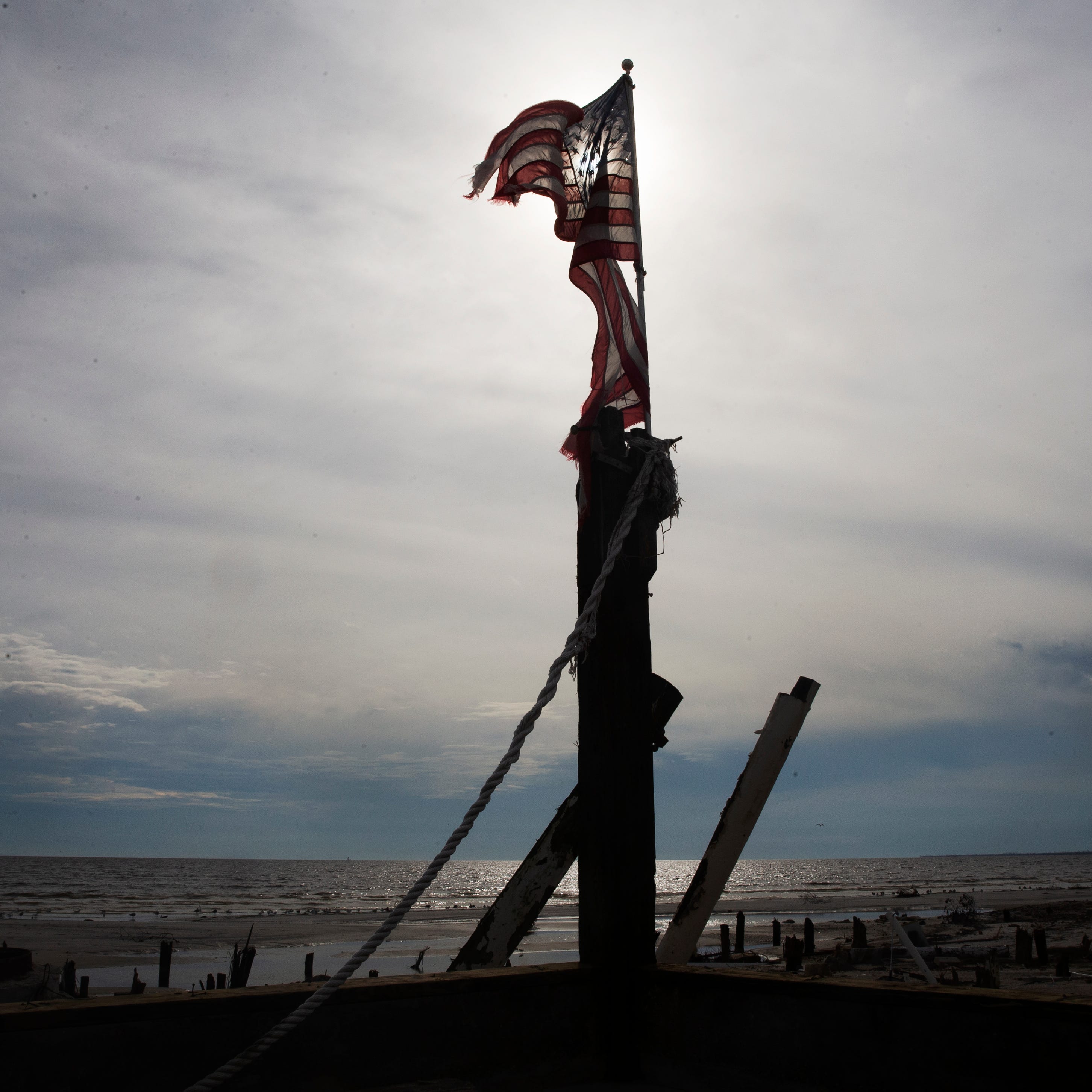 The Cottage Bar at Shuckers on Fort Myers Beach was destroyed  in Hurricane Ian.  An American flag was placed on one of the pilings that remain.  