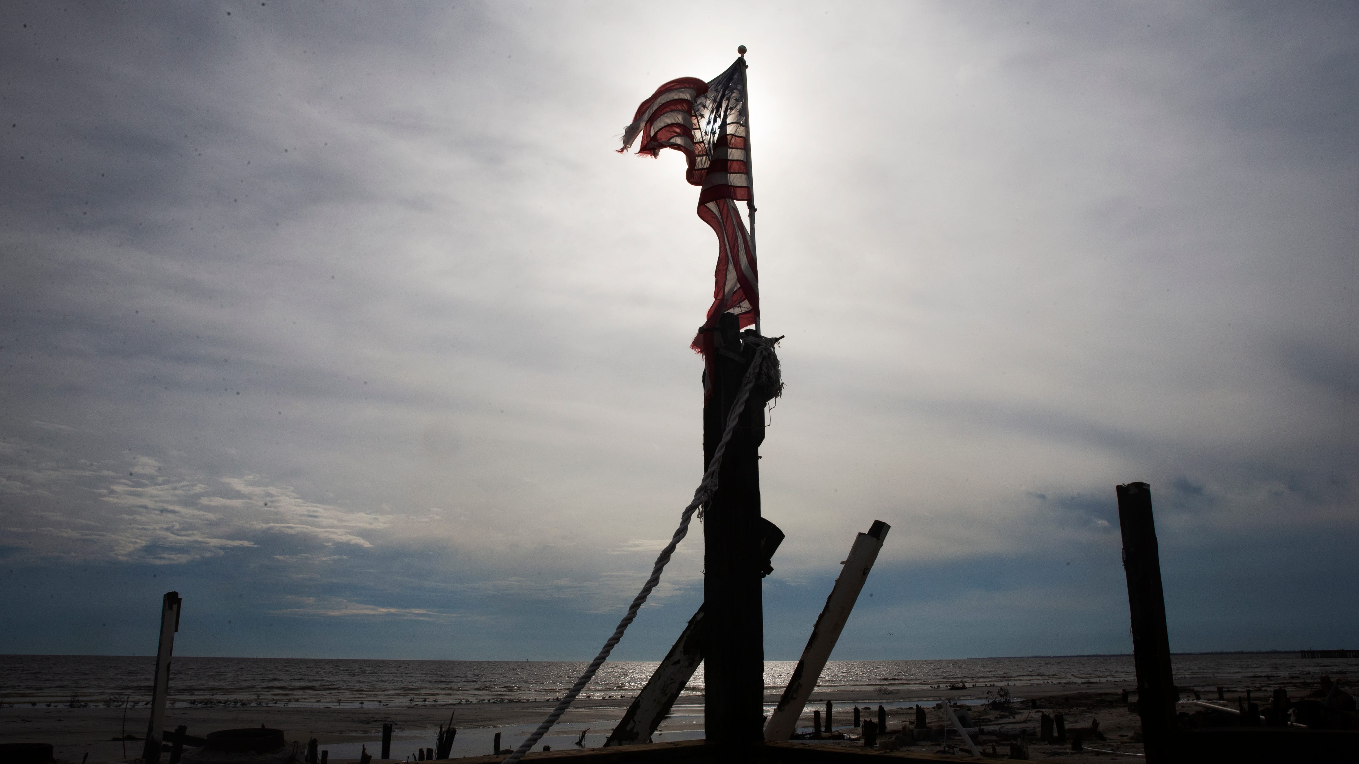 The Cottage Bar at Shuckers on Fort Myers Beach was destroyed  in Hurricane Ian.  An American flag was placed on one of the pilings that remain.  