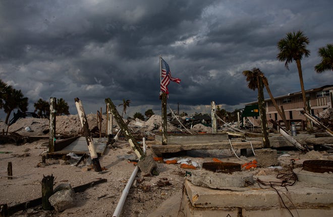 The Cottage Bar at Shuckers on Fort Myers Beach was destroyed in Hurricane Ian. An American flag was placed on one of the pilings that remains.