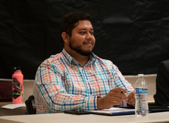 Miguel Martinez listens to other finalists give their opening statements at Neil Road Recreation Center on Oct. 19, 2022.