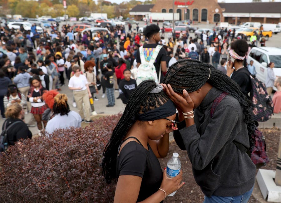 Students stand in a parking lot near the Central Visual & Performing Arts High School after a reported shooting at the school in St. Louis on Monday, Oct. 24, 2022.