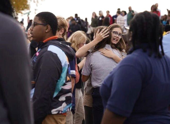 People gather outside after a shooting at Central Visual and Performing Arts high school in St. Louis, on Monday, Oct. 24, 2022.
