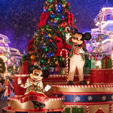 Mickey and Minnie wave to guests as snow appears t
