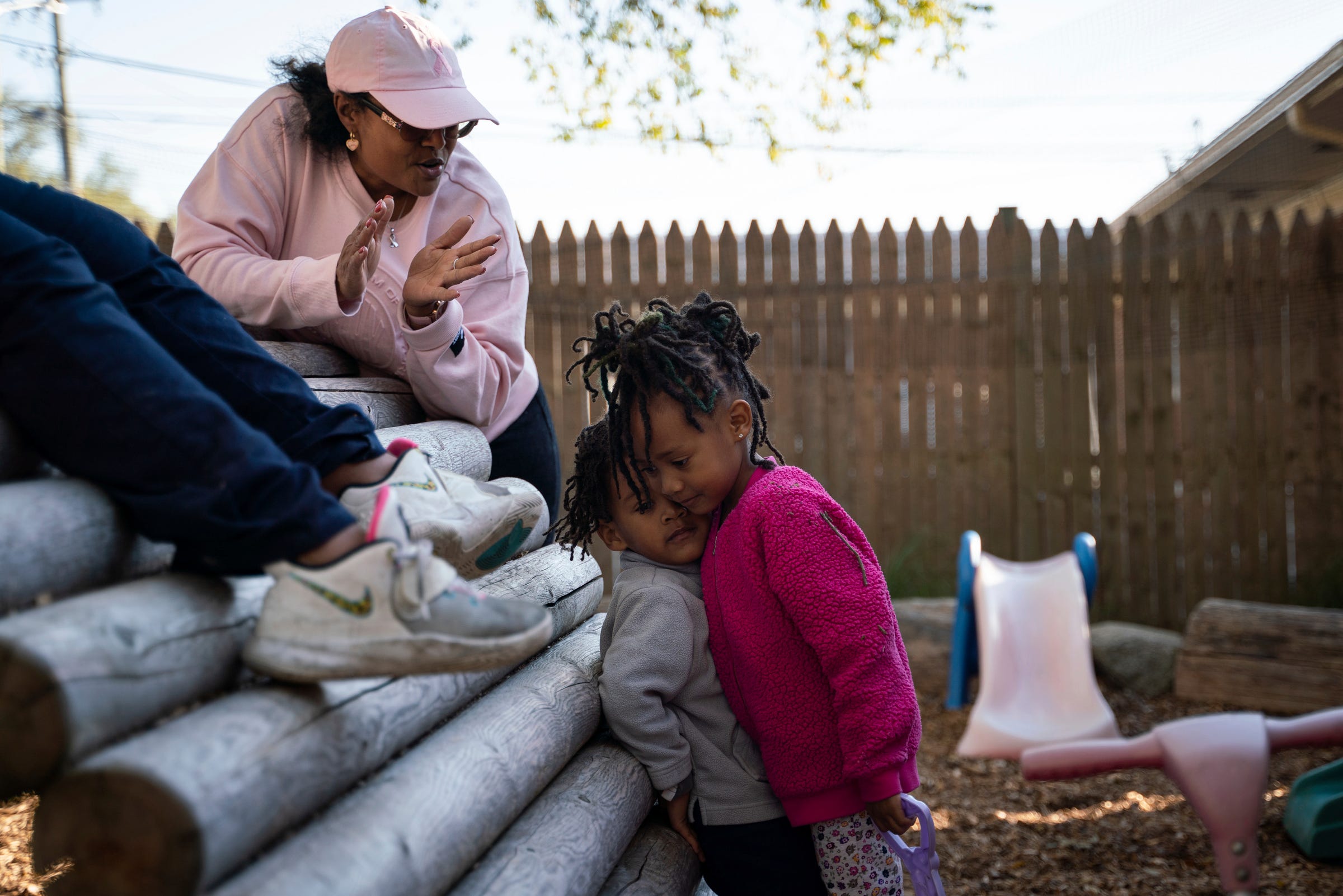 Day care owner Betty Henderson, 51, applauds as siblings Marz Simpkins, 3, and Montana Dunlap, 4, hug after apologizing for throwing tanbark at Angels of Essence Child Care Centre in Detroit on Friday, Oct. 21, 2022.