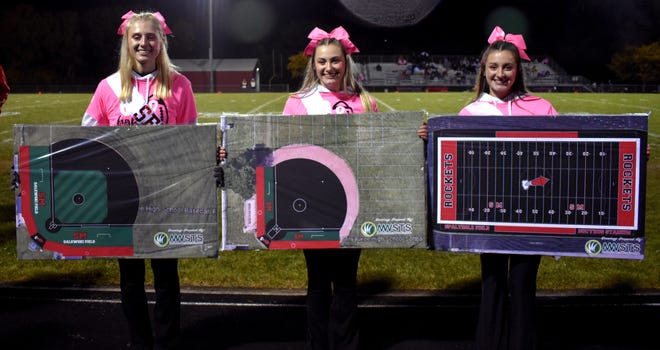 Members of South Milwaukee High School's cheerleading team hold renderings of what the school's new baseball, softball and football fields could look like as part of the South Milwaukee School District's "Leaving A Legacy" project.