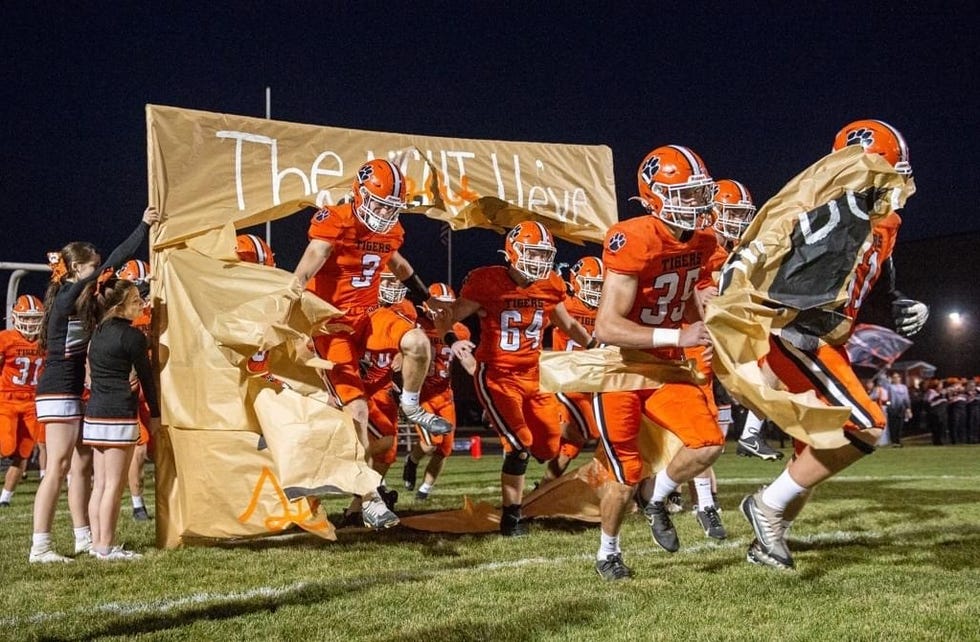 The Byron Tigers, shown here jumping onto the field for their regular-season finale in Byron on Friday, Oct. 21, 2022, is set to jump into the playoffs and defend their state title.