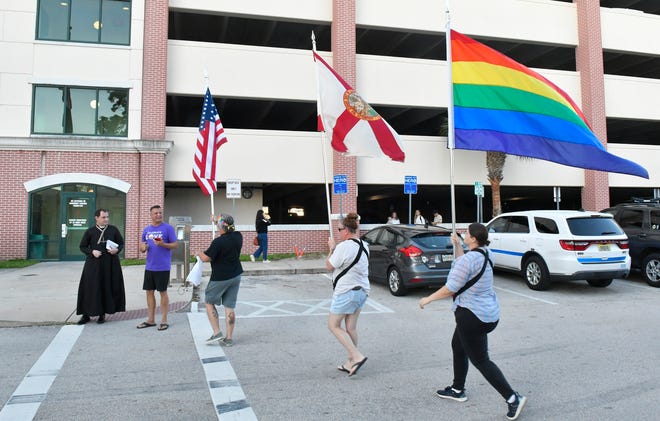 Members and supporters of Space Coast Pride gathered Tuesday night outside Melbourne City Hall and waved flags to Strawbridge Avenue traffic.