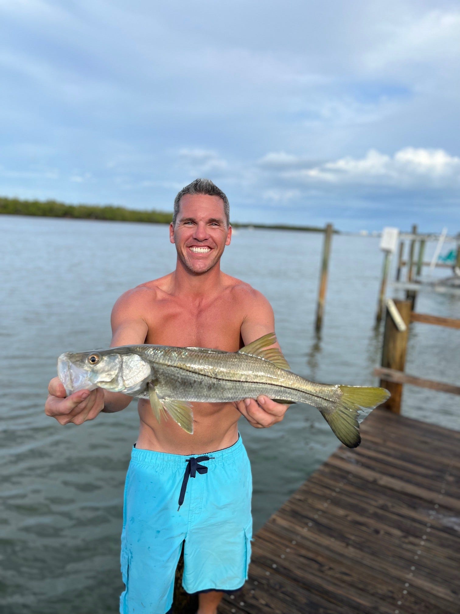 Mike Drumm shows off a snook he caught on the community dock on Hibiscus Drive in Fort Myers Beach in an image that was captured months before Hurricane Ian inundated the neighborhood and damaged the dock.