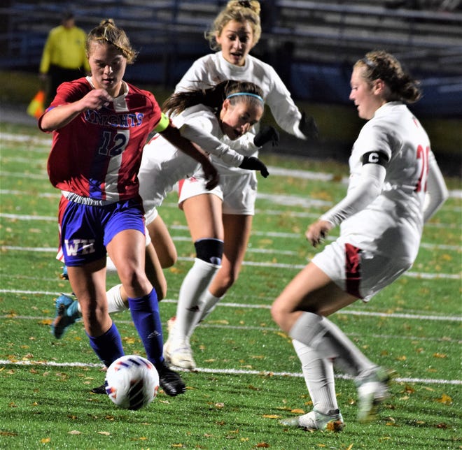 Allie McMillen dribbles through a trio of defenders. during the Knights' 6-2 victory in the Div. II East District semifinal at Cambridge.