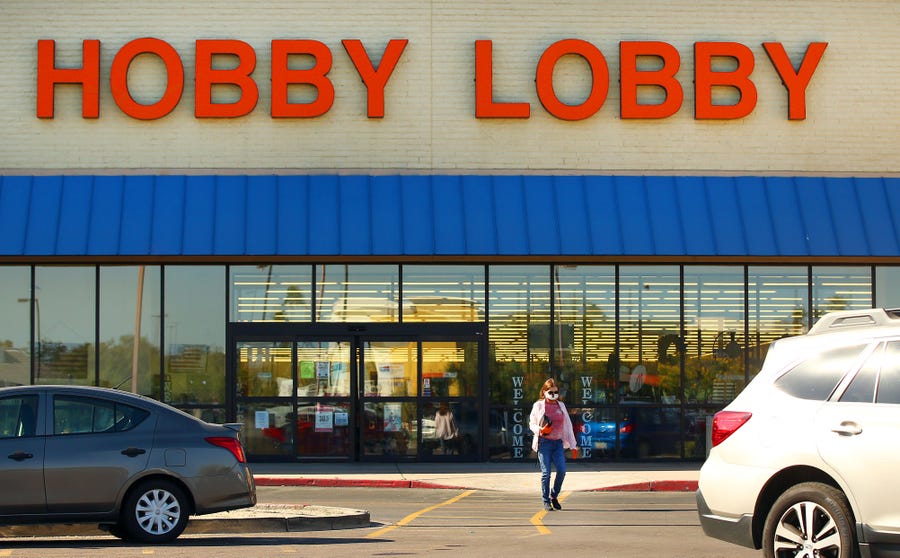 A shopper wearing a protective mask and gloves leaves Hobby Lobby at 4643 East Cactus Road during the COVID-19 pandemic in Phoenix.