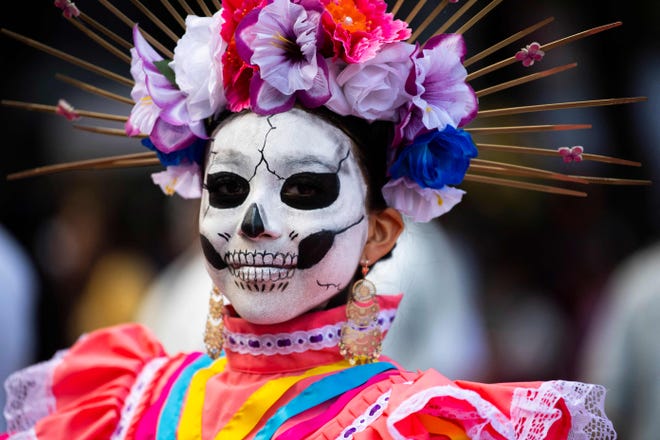 A woman fancy dressed as the character of La Catrina poses before taking part in the Catrinas Parade, commemorating the Day of the Dead, in Mexico City, on October 23, 2022.