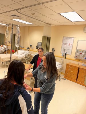 A student from Seacoast School of Technology in the Nursing Lab with a GBCC senior nursing student during Discovery Days event at Great Bay Community College.