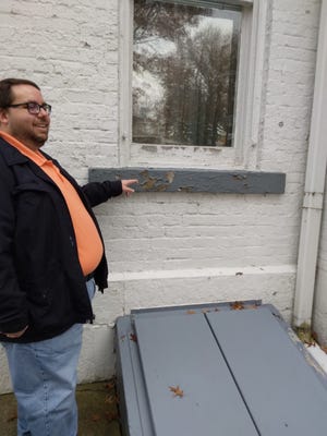 Nathan Bevil identifies the area where water is probably entering the Reeves Museum in Dover. Bevil was part of a Building Doctor team from the Ohio History Connection that visited the site on Thursday and Friday.