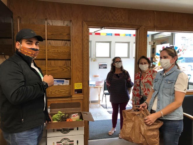 ogelio Contreras, left, community project coordinator for Wello, working with volunteers from Casa ALBA Melanie to package culturally relevant foods for Hispanic families in Brown County.