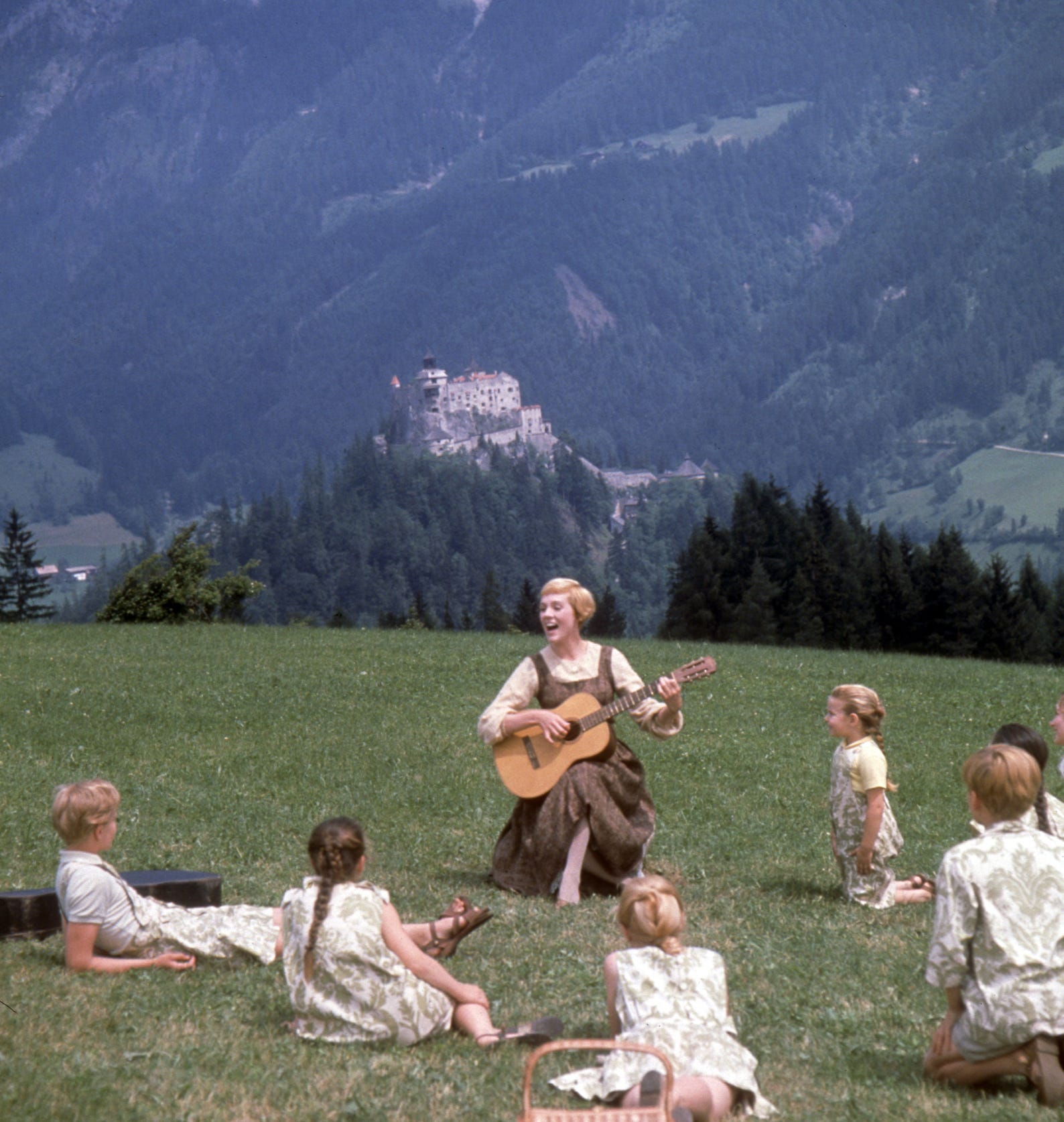 Strumming a guitar on an Austrian hillside, Maria (Julie Andrews) teaches the von Trapp family the joys of singing in "The Sound of Music."