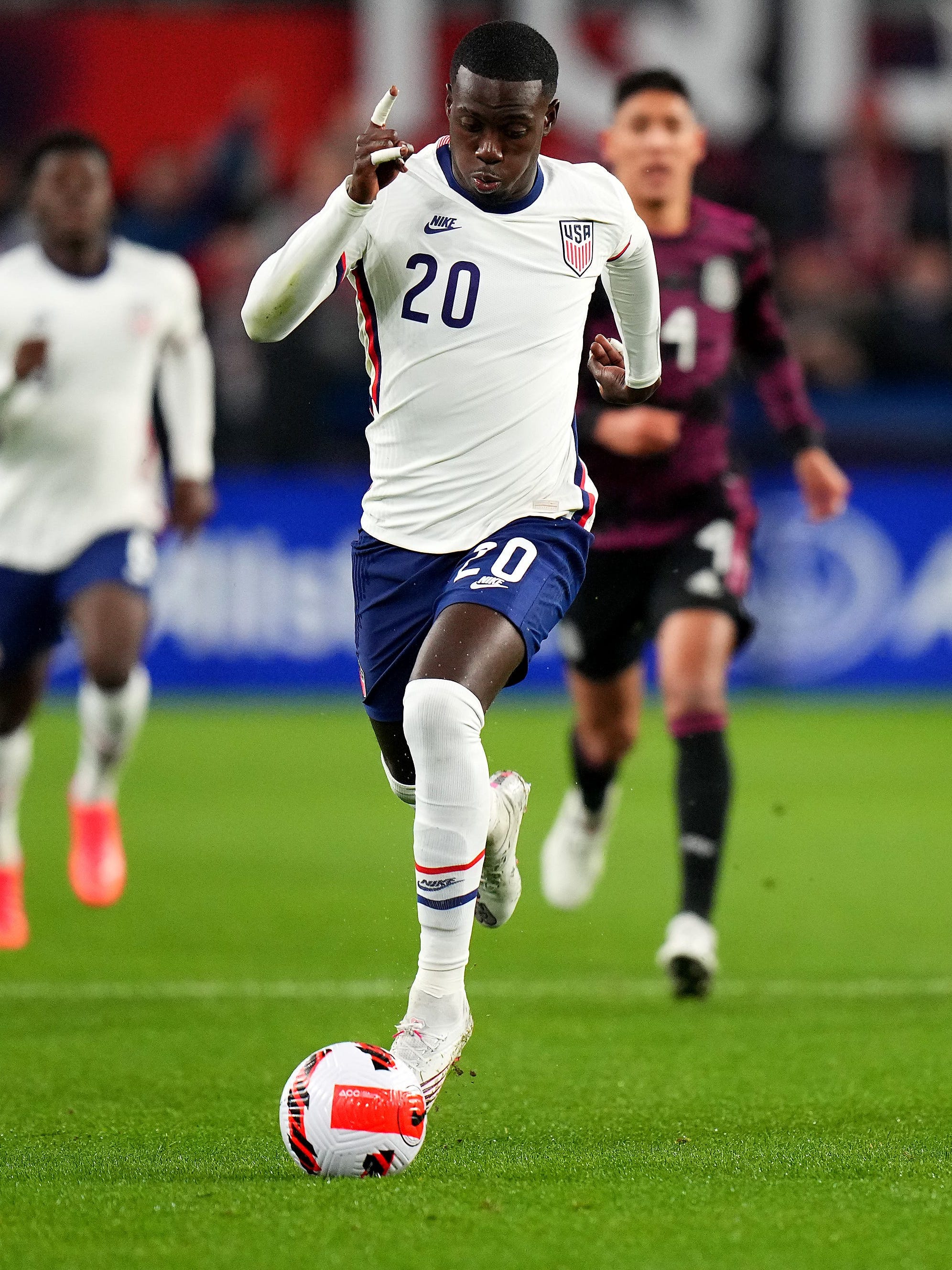 An action image of Tim Weah  playing soccer.