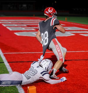 Farmington’s Ryan Connolly can’t stop Thomas Huss of Bedford from reaching the end zone during a playoff game. Huss is one of three Bedford players on the All-SEC Red football team.