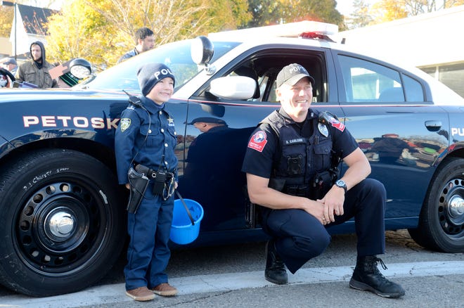 Officer Ben Carlson with the Petoskey Department of Public Safety poses for a photo with Oliver Juday prior to the start of the Petoskey Halloween parade on Saturday, Oct. 29, 2022.