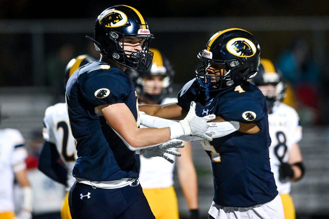DeWitt's' Bryce Kurncz, left, celebrates his touchdown with Blake Haller during the first quarter in the game against Cadillac on Friday, Oct. 28, 2022, at DeWitt High School.