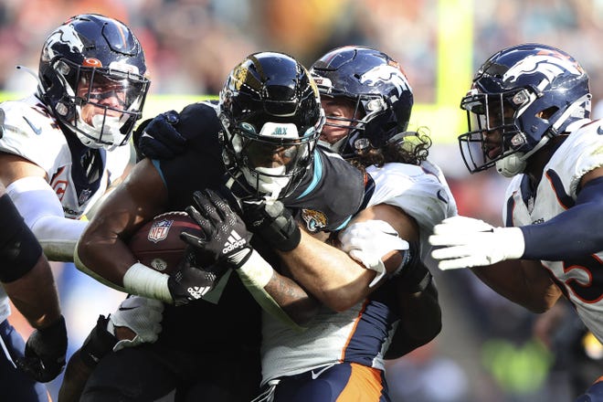 Denver Broncos linebacker Josey Jewell (47), sercond right, tackles Jacksonville Jaguars who defeated Travis Etienne Jr.  (1) during the NFL football game between Denver Broncos and Jacksonville Jaguars at Wembley Stadium in London, Sunday, October 30, 2022. (AP Photo/Ian Walton)