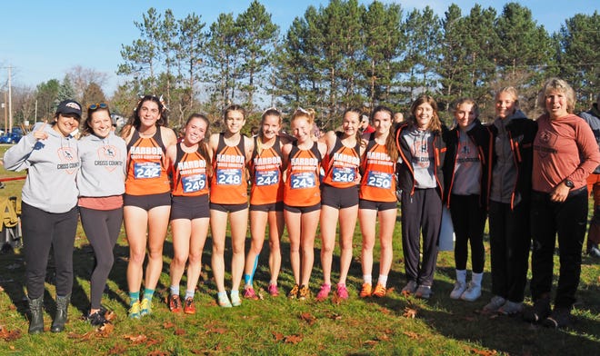 The Harbor Springs girls' cross country team celebrates its first regional championship since 2016 in East Jordan Saturday following their Division 4 race.