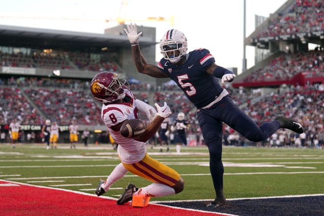 October 29, 2022;  Tucson, Arizona, USA;  Arizona Wildcats safety Christian Young (5) breaks up a pass intended for USC Trojans wide receiver C.J. Williams (8) during halftime at Arizona Stadium.  Mandatory credit: Joe Camporeale-USA TODAY Sports
