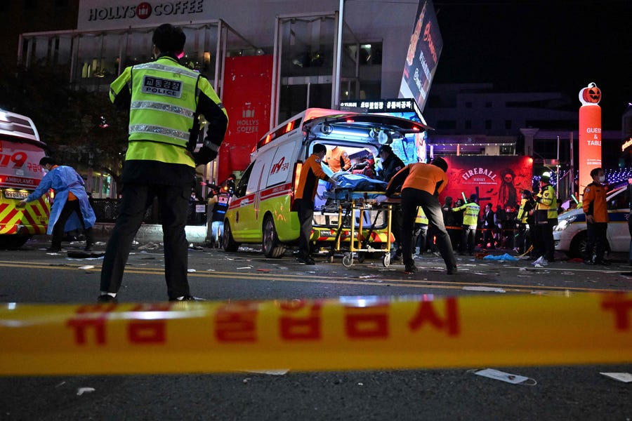 Medical staff attend to a person on a stretcher in the popular nightlife district of Itaewon in Seoul on October 30, 2022.  Dozens of people suffered from cardiac arrest in the South Korean capital Seoul, after thousands of people crowded into narrow streets in the city's Itaewon neighborhood to celebrate Halloween, local officials said. 