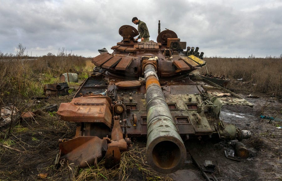 A Ukrainian soldier inspects a Russian tank in that was damaged in recent fighting near the recently retaken village of Kamianka, Kharkiv region, Ukraine, Sunday, Oct. 30, 2022.