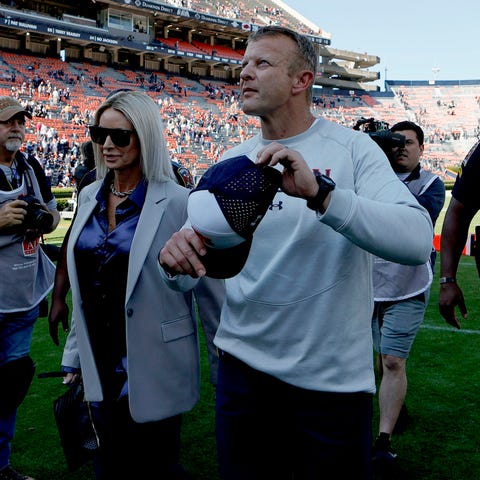 Bryan Harsin and his wife, Kes, walk off the field