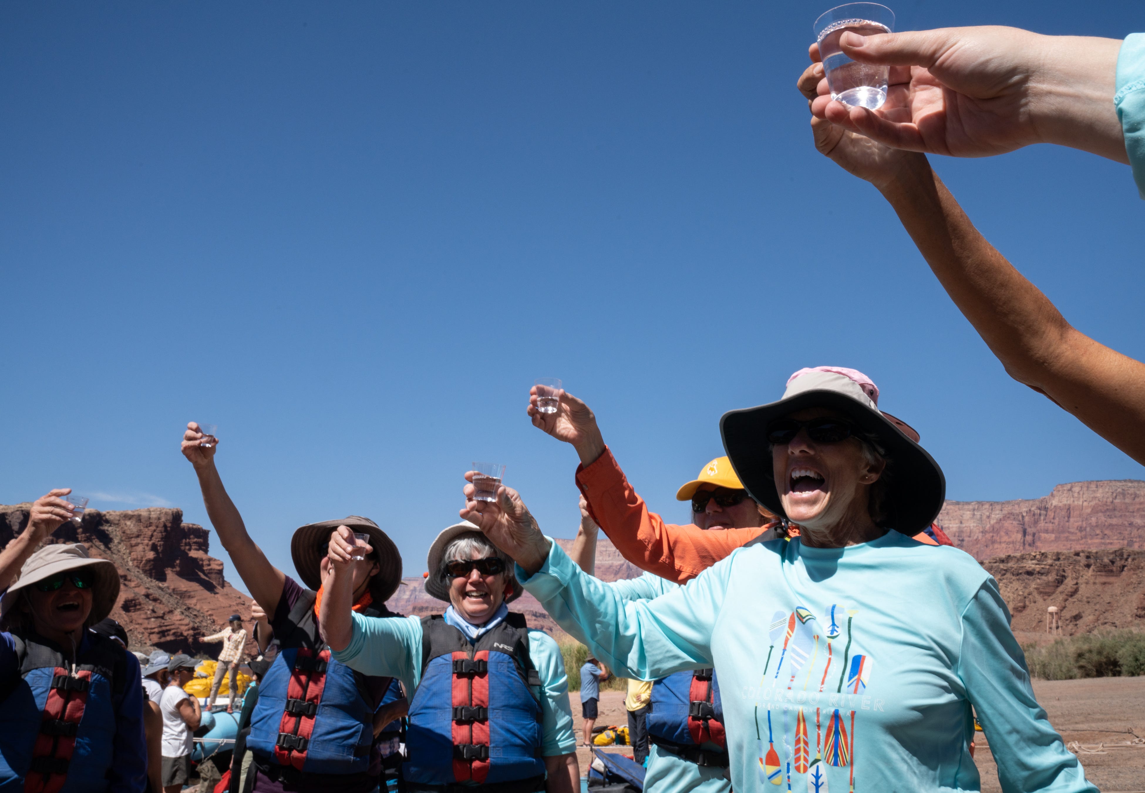 Jar Mortenson, right, leads a group of rafters from Wyoming toast their journey before they start an eight-day trip down the Colorado River through Grand Canyon on May 25, 2022, at Lees Ferry in the Glen Canyon National Recreation Area. Some of the friends fear climate change will permanently challenge their state’s water supply, but, Mortenson said, “I believe things will correct themselves.”