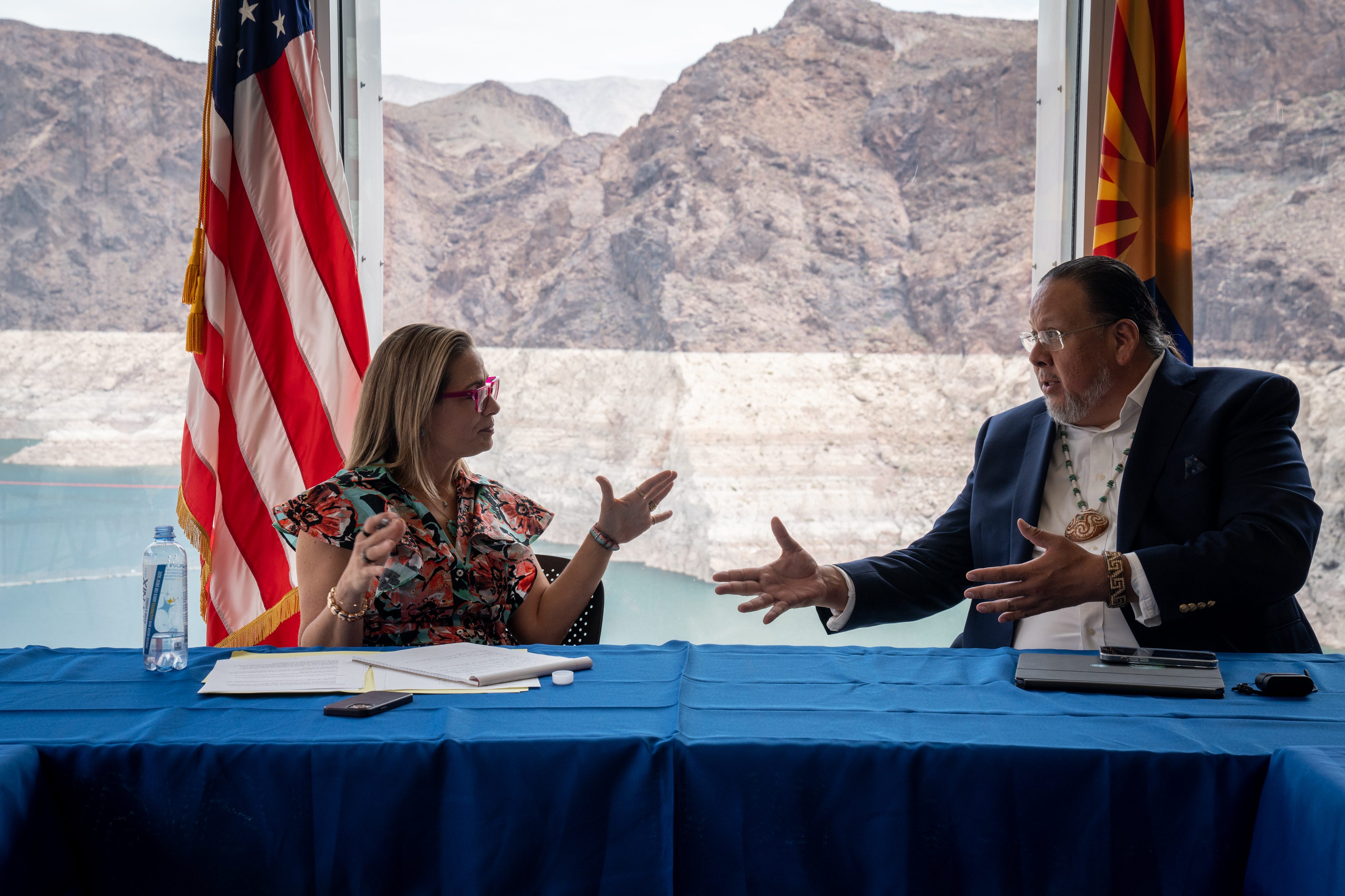 Sen. Kyrsten Sinema and Gov. Stephen Roe Lewis of the Gila River Indian Community talk during the Water Advisory Council meeting on Aug. 8, 2022, in the Hoover Dam Spillway House. Lewis’s community is participating in a federal program that pays rights holders to leave Colorado River water in Lake Mead, with funds that Sinema worked to include in climate-adaptation legislation this year.