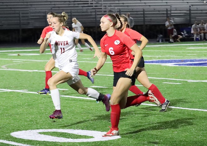 Dover's Alyssa Feller and New Philadelphia's Caycee Dawson race to get to the ball during Tuesday's Division II regional semi-final at McFarland Stadium in Cambridge.