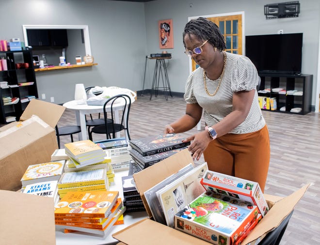 Nicole Dixon sorts a selection of books she plans to sell at her new Black Café and Bookstore on Wednesday, Nov. 2, 2022. The store will open for business on Nov. 12.