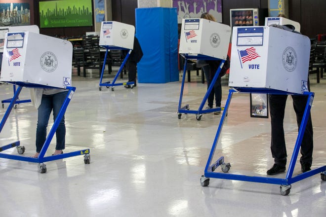 People in privacy booths vote in next week's midterm election at an early voting polling site at Frank McCourt High School on the Upper West Side of Manhattan in New York City on Tuesday, November 1, 2022.