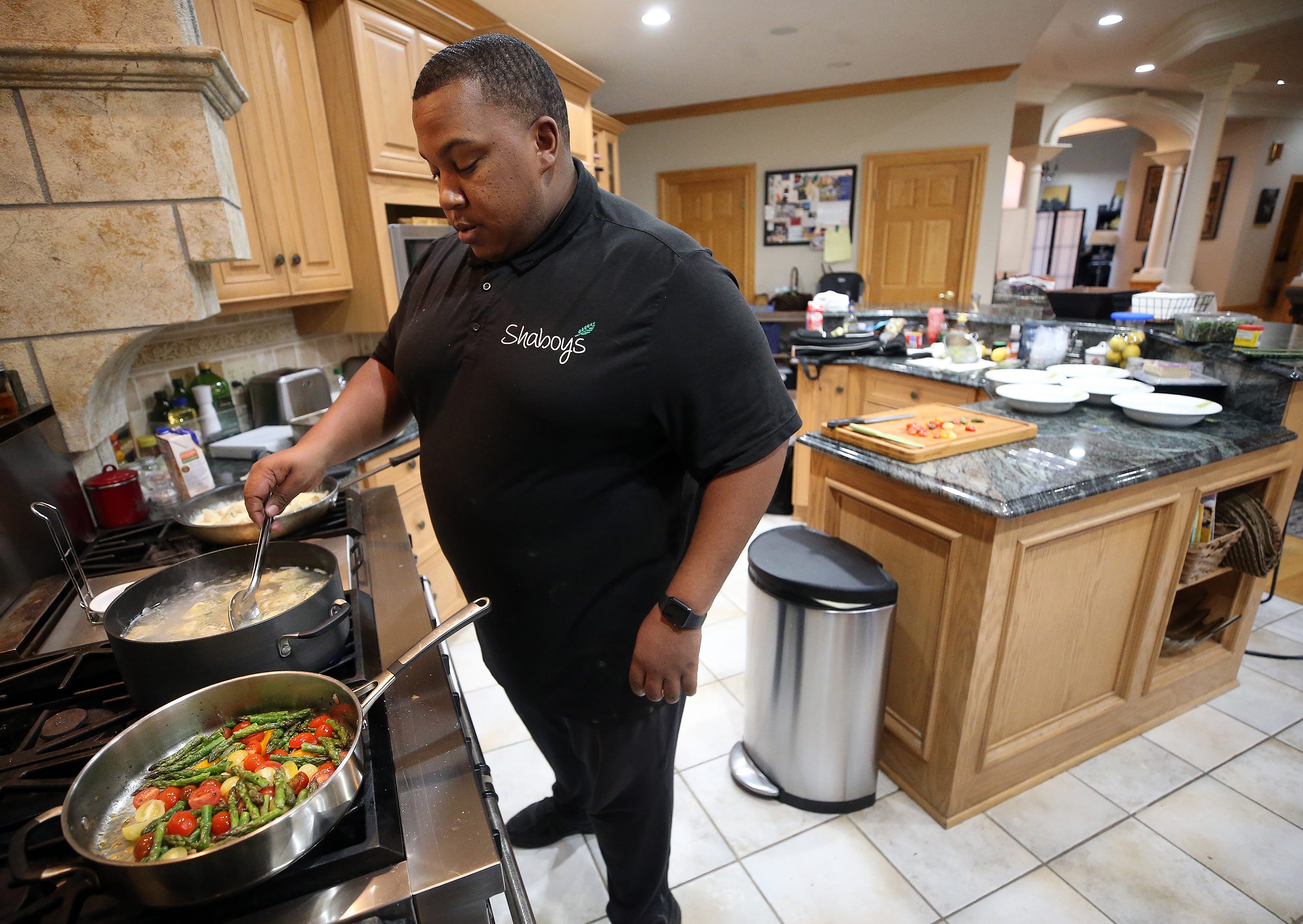 Private chef Dion Millender prepares a meal at a client's home, Sunday, Oct. 30, 2022, in Akron, Ohio.