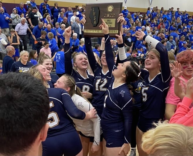 Aquin players hold up the sectional plaque and celebrate Wednesday's 25-14, 25-19 victory over Galena in the Class 1A Pecatonica volleyball sectional.
